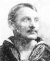 Head of a white man with mustache wearing a sailor suit with a wide flat collar open at the front.
