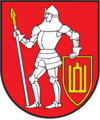 A coat of arms depicting a man in full body armour holding a white spear in his right hand and a red-and-yellow shield in his left hand