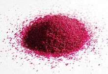 a pile of red granules on white paper