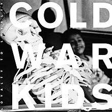 The cover features the band's logo in bold white letters. Behind the logo, there's a picture of a young boy and a skeleton with a screw on top of its head in the backseat of a vehicle.