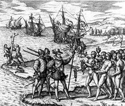Europeans and natives meeting, with ships and a missionary cross in the background