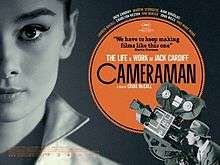 A movie poster dominated by a picture of Audrey Hepburn and a cameraman and his camera in the right hand bottom corner pointing up at her.
