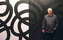 Corey Postiglione, in front of his black-and-white, site-specific painting, Population 5, at his exhibition of the same name.