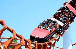 Photograph of a red roller-coaster performing a loop.