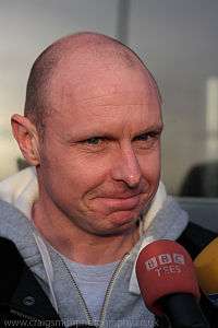 Head of a bald white man facing a BBC microphone.