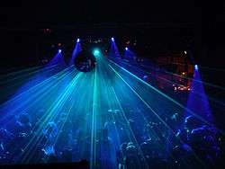 Crowd of dancers under a disco ball and laser light show