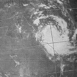 Satellite image of a tropical cyclone near the northeastern coast of Australia. Curved rainbands are shown but no eye is visible.