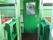 A view of the inside of a caboose with railroad track visible through one of its windows