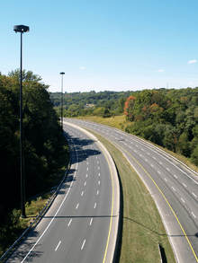 An empty six-lane highway in a forested valley