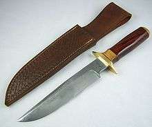 Large knife with polished wooden handle, lying next to a leather sheath