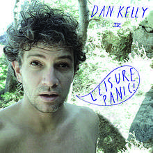 The main image is an upper body shot of the artist, who appears shirtless. He has a surprised, tired or annoyed look. In the background is a garden or beach-side scene with large plants, rocks and a body of water just visible over his right shoulder. The artist's name is written at top right in all capitals and bright purple script. Below in small script but same colour are the Roman numerals IV. In a cartoon-like speech bubble, near his open mouth, is the album's title in the same style script.