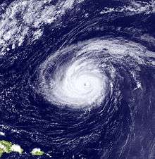 A satellite image depicting a mature hurricane with a well-defined eye far away from landmasses.