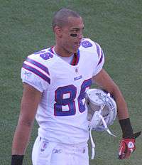 David Nelson walking in the white uniform of the Buffalo Bills with his helmet under his arm.