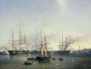A number of large, tall ships on calm seas. The ship in the center is flanked by a number of smaller rowboats with people on them.