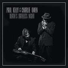 The artists' names are written in white on black background at top left. Album title is below. Main image show two men: the one at left is sitting to play a lap steel guitar; the other man is standing to play a harmonica