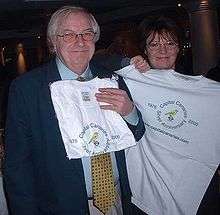 A man and a woman holding white T-shirts in front of themselves