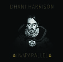 A black-haired, Caucasian man's face on a black background. All text on the cover is gold. Above his head are the words "DHANI HARRISON," and below reads "IN///PARALLEL," surrounded by what appear to be two pine cones.