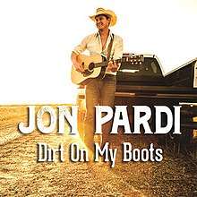 An image of a man playing a guitar on a dirt field with a pickup truck and sunlit background behind him. The artist's name and song title are superimposed over the image.