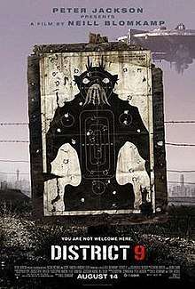 On dirty dusty ground, a black and white target practice poster of a bipedal insect-like creature stands, riddled with bullet holes. Barbed wire runs behind the poster and a large circular spaceship hovers in the background.