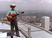 1980 colour photograph of Donn Reynolds performing outside atop the main deck roof of the CN Tower (Toronto, Ontario, Canada).