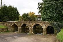 Stone bridge with four arches and low parapet.