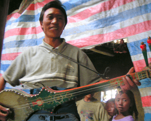 Tibetan man playing a dramyin.
