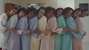 A group of women holding each other while wearing bathrobes.