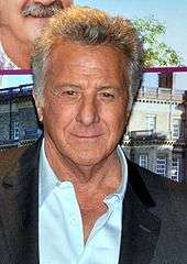 Photo of Dustin Hoffman—a 74-year-old white man with gray hair, small eyes and a big nose, wearing a black blazer over a light blue casual shirt—attending the French premiere of his film, Quartet, in 2013.