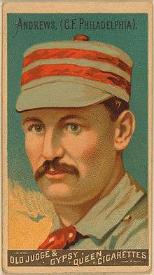A baseball-card image of a mustachioed man wearing a red-and-white striped pillbox hat