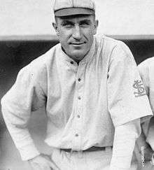 A man in an old-style white baseball uniform with an interlocking "StL" on the left sleeve
