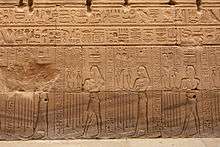 Relief showing four people with varying sets of hieroglyphs on their heads