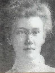 portrait of a lady with high necked blouse, hair up and with glasses