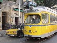 Yellow tram next to a yellow car