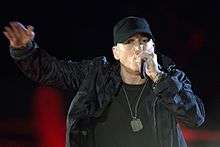 Eminem in military gear rapping into a microphone