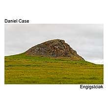 An image of a large rocky outcrop over a grassy plain under an overcast sky, rectangular on a square white background. Left justified text above the image reads "Daniel Case"; right justified text below says "Engigstciak"