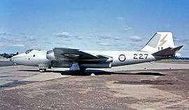 Twin-engined silver military jet parked on tarmac