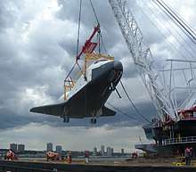 Weeks 533, a crane barge, lifts the Space Shuttle Enterprise