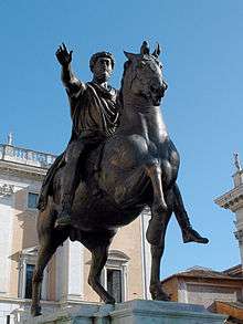 Statue of a man sitting upon a horse and lifting his right arm