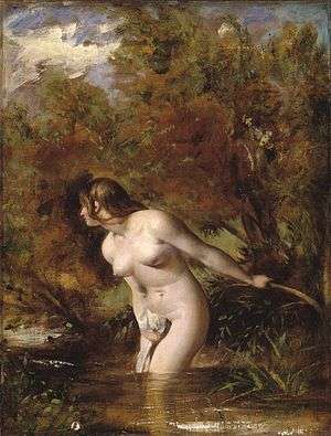Naked woman standing in a stream