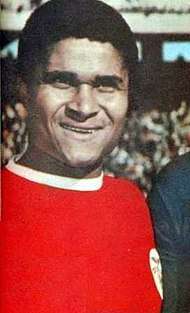 A smiling man wearing a red shirt