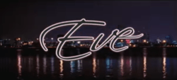 The word Eve is written in black cursive font and is presented against a nighttime panoramic image of downtown Miami.