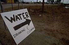 A sign indicating a relief camp providing water for cleaning and drinking