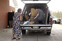 Photograph of Camp Sister Spirit resident donating supplies to church community.