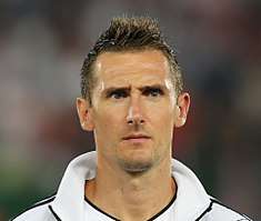 Photographic portrait of Klose's face and shoulders. He is wearing a white tracksuit top.