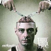 A color photo of Fabri Fibra's head, with the top half of his skull exposed, revealing his brain and two hands using utensils and preparing to eat it.