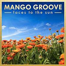 Album cover: An photograph of orange sunflowers under a deep blue sky streaked with whispy clouds. The artist name and album title are in gold sans-serif lettering at the top of the photo. The border of the photo is also gold.