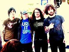 Fall Out Boy standing still while posing for a camera.