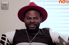 Falz wearing a red hat and a pair of round lens glasses