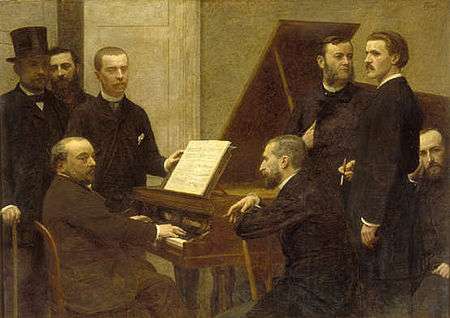 group of middle-aged men standing and sitting round a piano