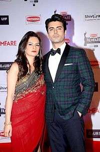 Fawad and Sadaf Khan, formally dressed and striking a serious pose